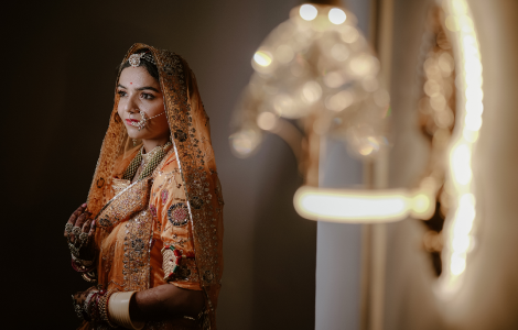 Indian bride in a vibrant orange sari, beautifully captured in bridal photography.