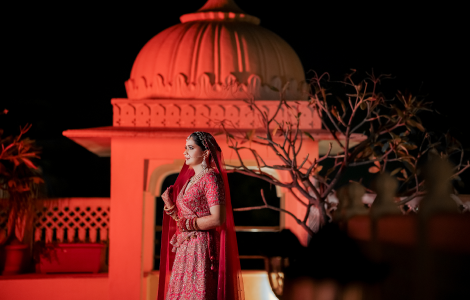 A beautiful bride in red, gracefully posed at night, highlighting bridal photography.