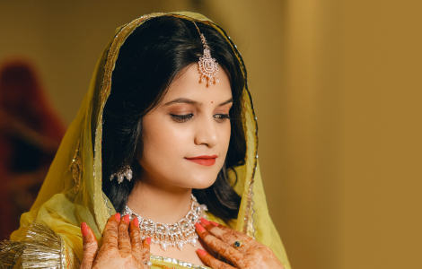 A beautiful Indian bride wearing a bright yellow sari, elegantly portrayed in bridal photography.