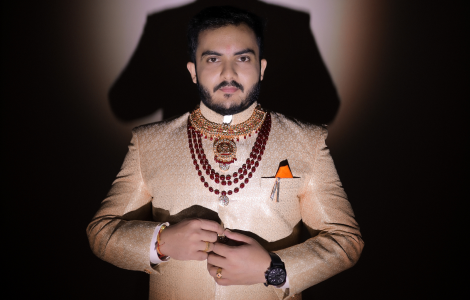 A groom in a bold gold and red outfit.