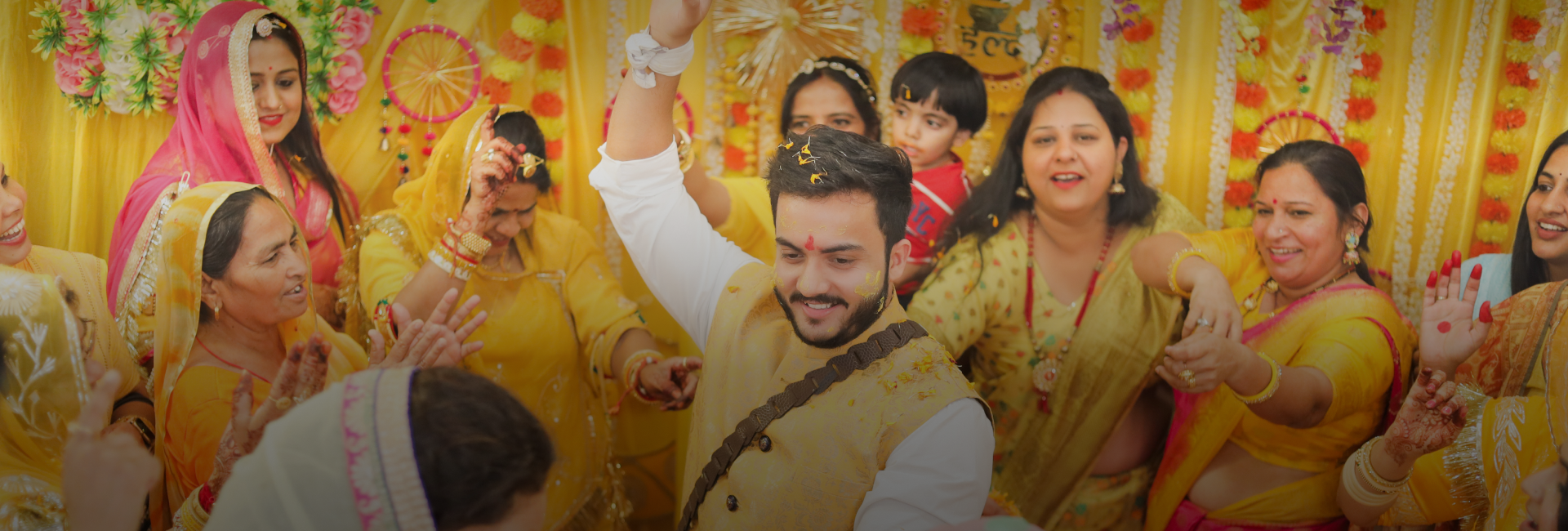 A vibrant group in yellow celebrating the Haldi ceremony.