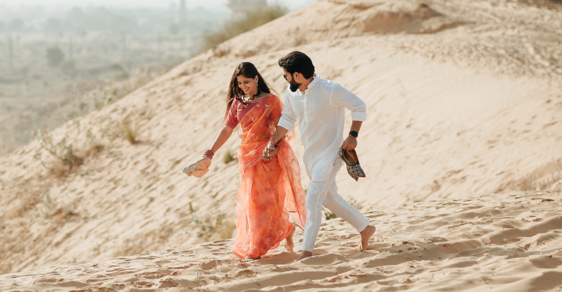 A couple enjoys a peaceful walk in the desert.