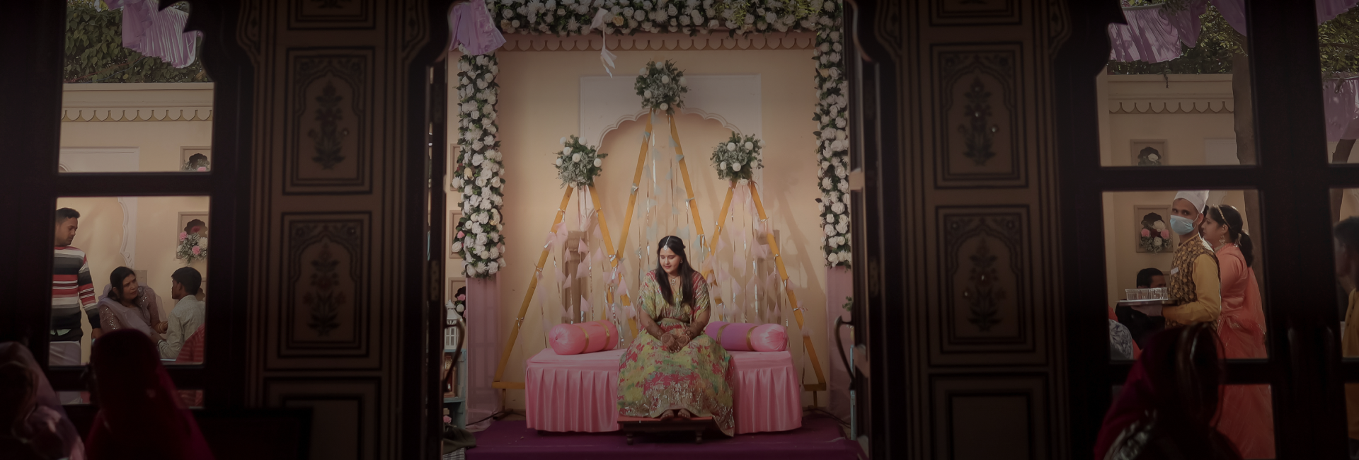 A romantic wedding ceremony set in a room with a pink chair - mehendi photography.
