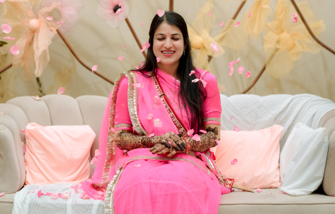 A woman in a pink sari, showered by rose petals - mehendi photography.