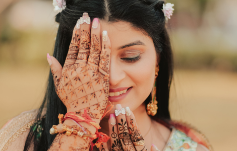 A graceful Indian bride displaying exquisite henna on her hands - mehendi photography.