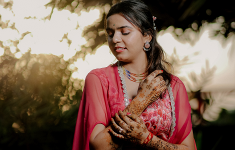 A lovely Indian bride in a pink outfit, her hands adorned with stunning mehendi.