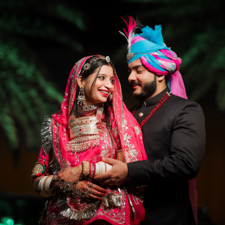 A couple dressed in traditional Indian clothing, showcasing luxurious fabrics and intricate patterns.