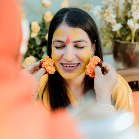 A woman adorned with bright yellow face paint, highlighting her features in a bold and creative manner.