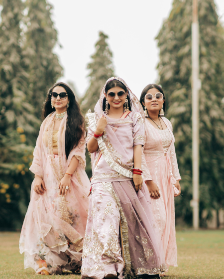 A trio of women dressed in traditional Indian attire strolls together.