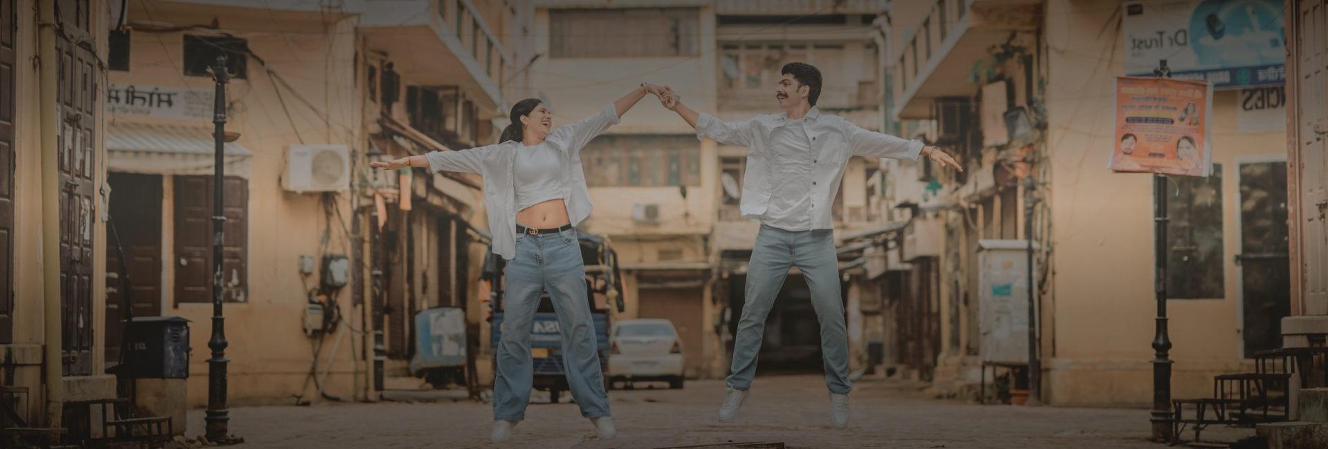  A couple in jeans playfully stacked in an alley.