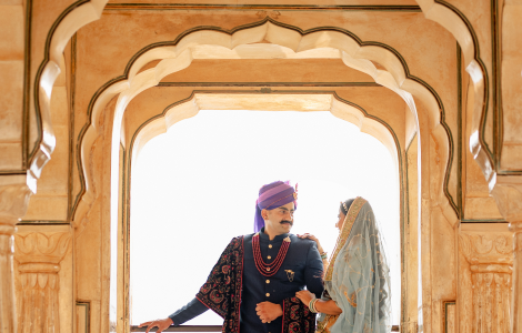 A couple in vibrant traditional Indian clothing smiles together - pre-wedding photography.