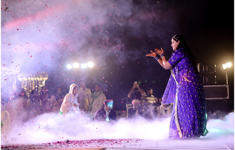 A woman dressed in a colorful sari performs a heartfelt song at a wedding - sangeet photography.