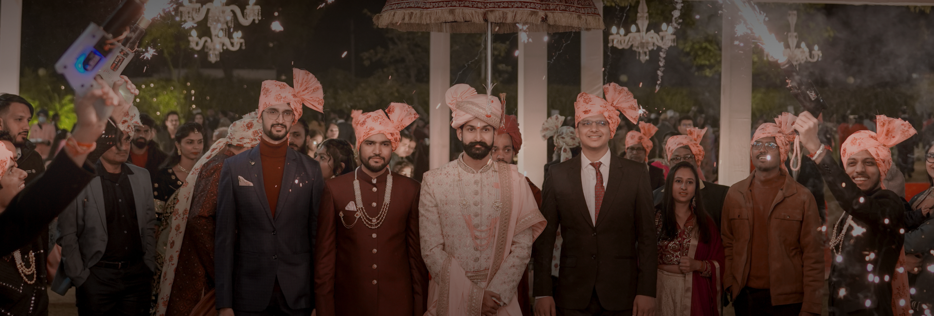 A gathering of people in colorful traditional Indian clothing, beautifully posed for wedding photography.