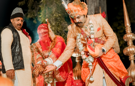The bride and groom at an Indian wedding ceremony, adorned in traditional attire, amidst colorful decorations and celebrations.
