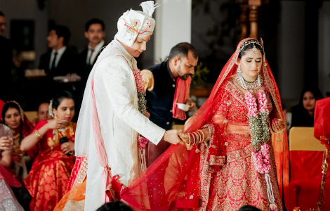 A bride and groom in traditional Indian attire, radiating joy and elegance during their wedding ceremony.